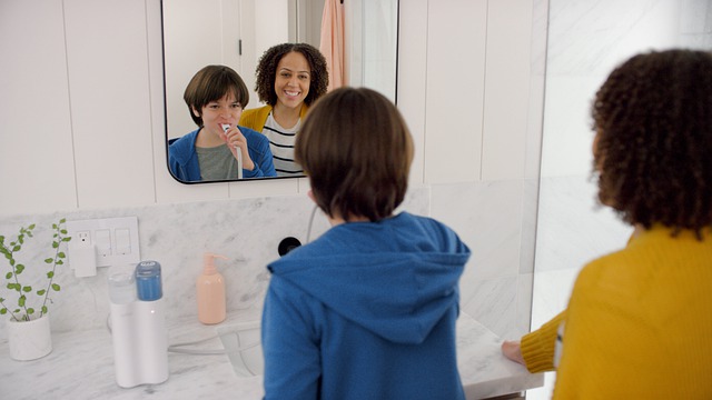 A mom and son brushing teeth in bathroom