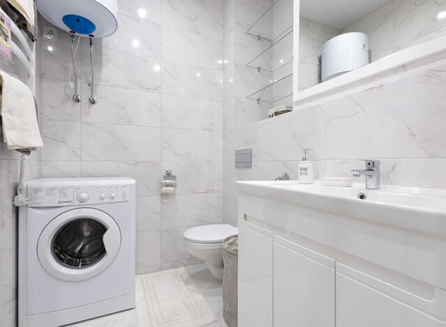 Washing machine in white bathroom