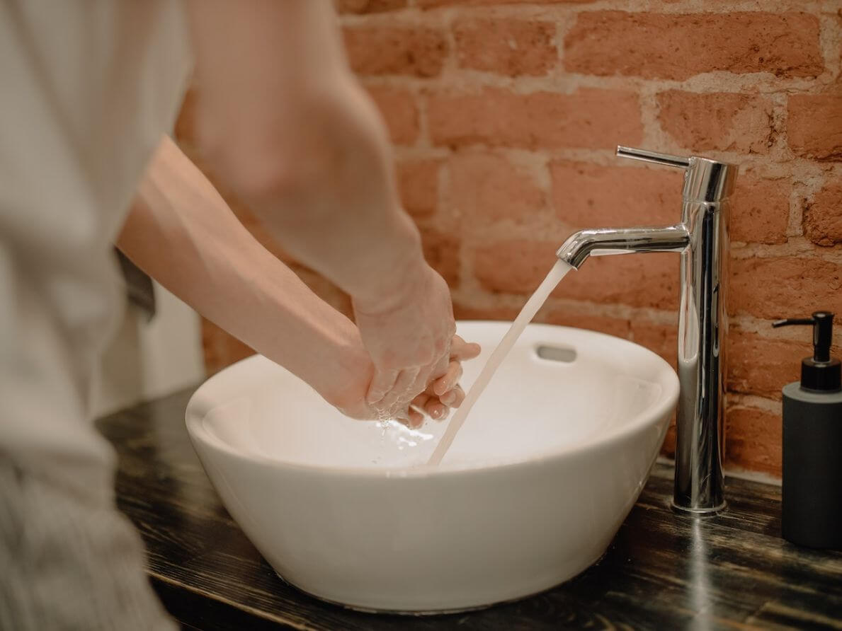 Hands washing in bowl sink