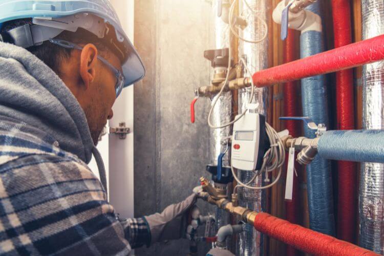 man inspecting hot water system